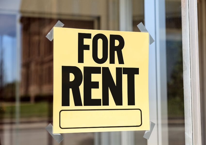 Yellow “for rent” sign posted in a window