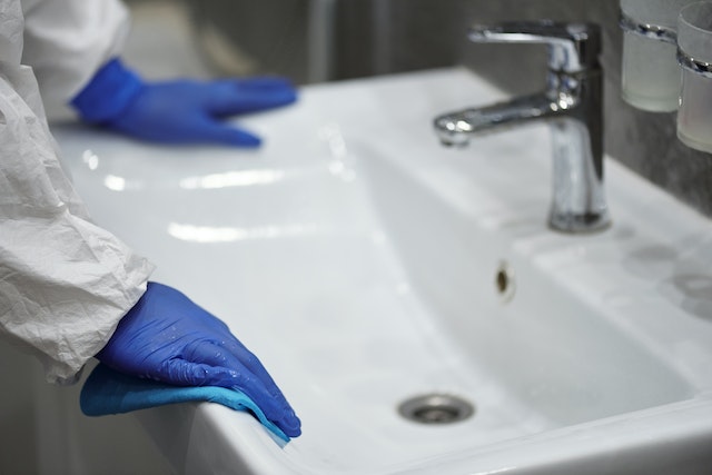 a-person-wearing-gloves-examining-a-sink