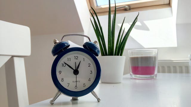 a blue alarm clock on a white table