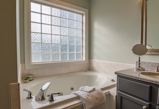 neutral bathroom with large bathtub and picture window