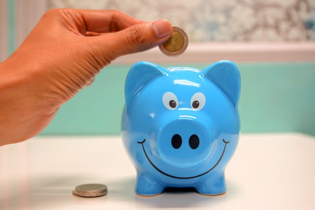 a-person-putting-money-in-piggy-bank